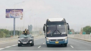 Hành động nguy hiểm: Trẻ em thò đầu ra khỏi cửa nóc của xe ô tô trên đường